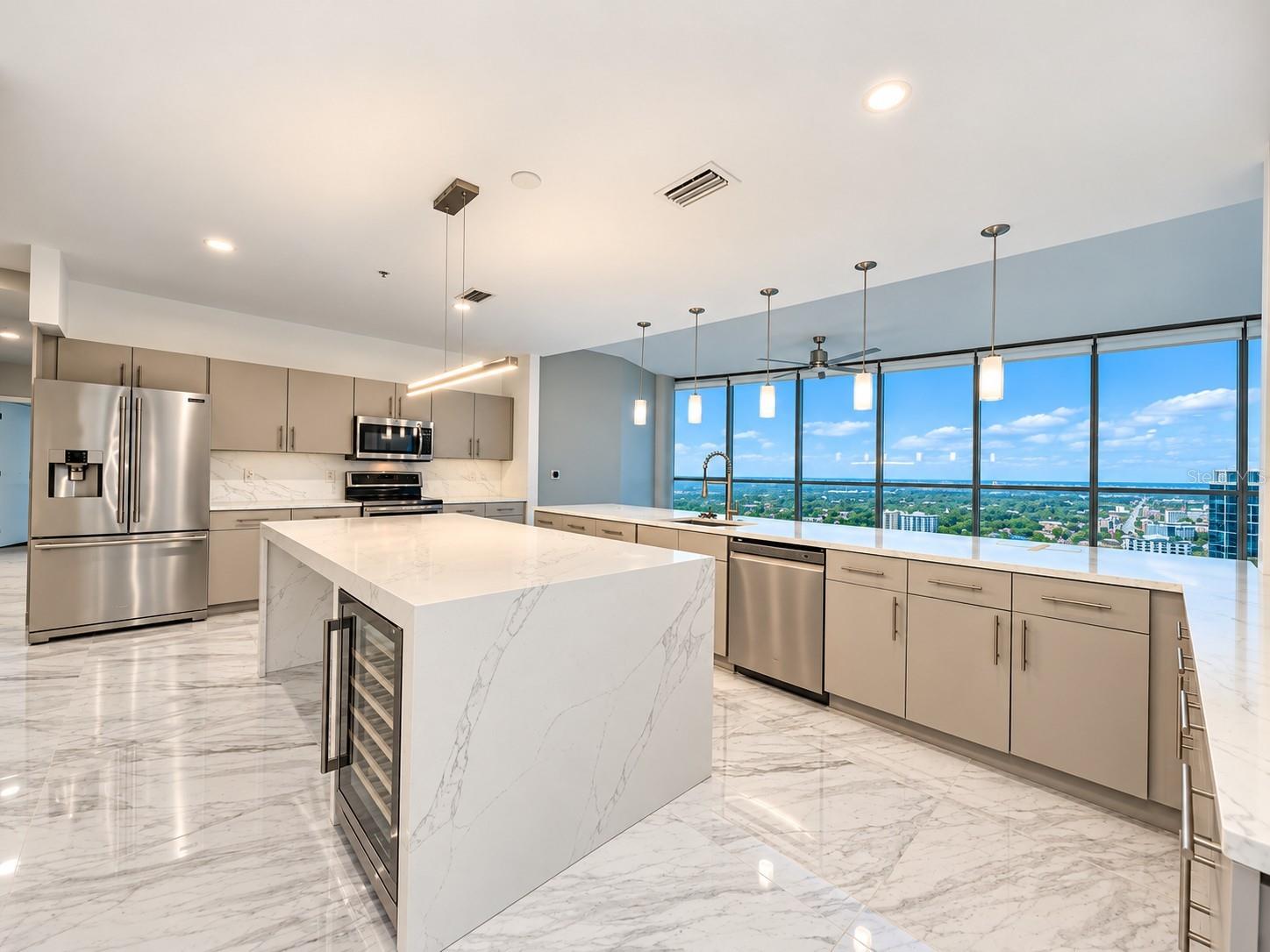 Oversized kitchen with stone countertops and a waterfall island in the Aspire penthouse