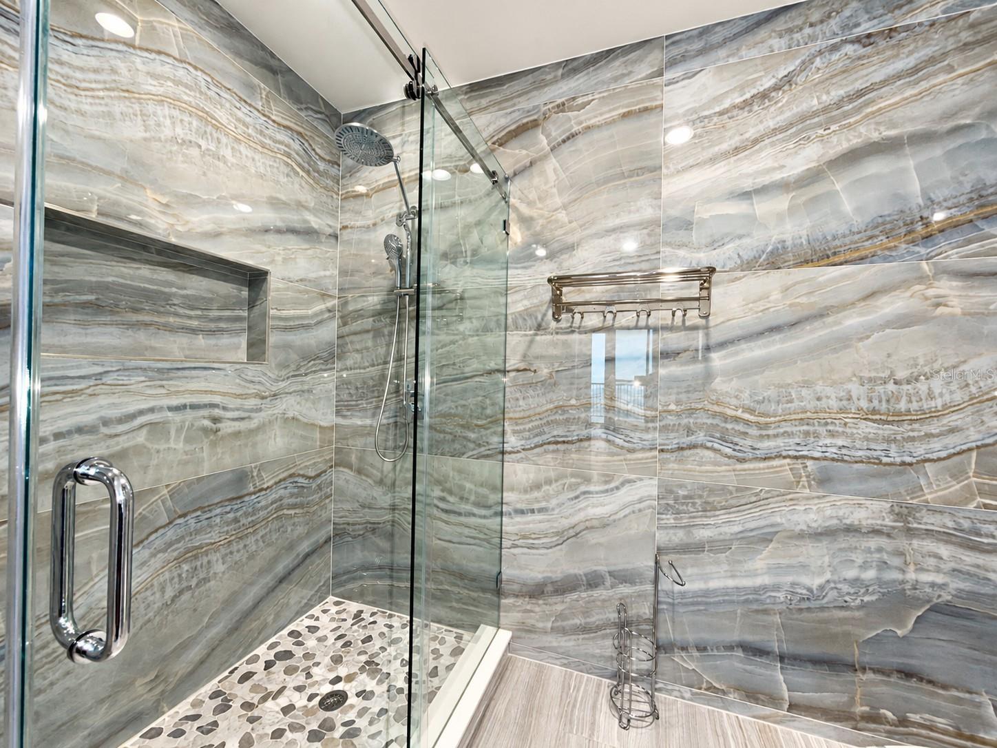 Frameless glass shower with dual shower heads in the Aspire penthouse primary bath